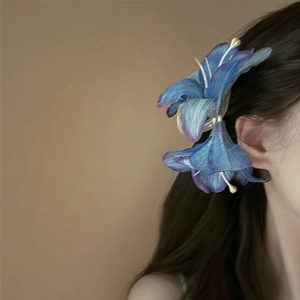 Blue gradient acrylic lily flower hair claw clip worn by a model for an elegant look