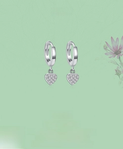 Detailed macro of S925 sterling silver hoop earrings with sparkly heart zircon pendants