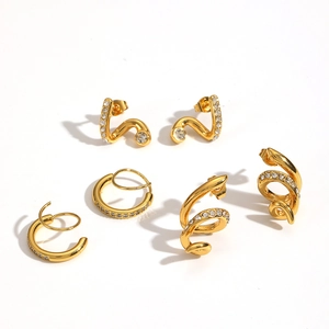Gold snake-shaped and U-shaped earrings with rhinestones on a white background
