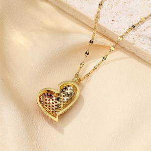 Detail of gold heart pendant with micro-paved red and white zircons on silk fabric