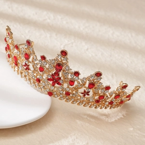Detailed view of a gold alloy bridal crown with red and white rhinestones and floral patterns