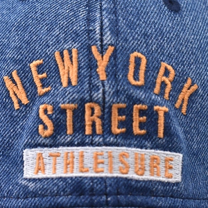 Blue denim baseball cap with orange New York embroidery in a vintage washed style