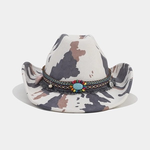 Detailed view of western cow print fedora featuring turquoise bead and tassel band decoration