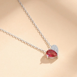 Rose gold heart pendant necklace with pear-cut red gemstone and sparkling pavé diamonds