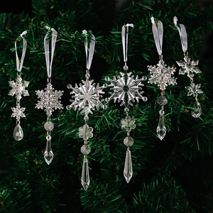 Close-up of 6 transparent acrylic snowflakes and icicle ornaments on a Christmas tree