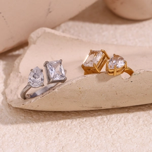 Close-up of teardrop and rectangular zircons on gold and silver open rings