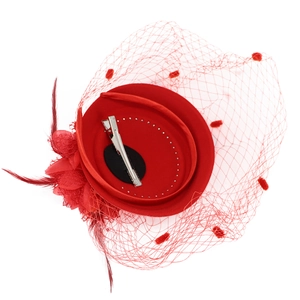 Red fascinator hat with mesh veil and feathers shown with secure hair clip back
