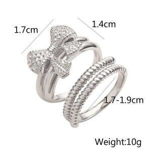 Detail view of 18K gold plated bow ring set with zircon accents and spiral band
