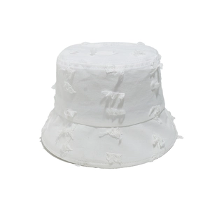 Close-up of a white cotton bucket hat featuring distressed fringe and frayed details