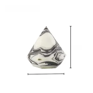 Detail view of a 50mm diamond-shaped makeup sponge with grey marble texture and faceted cut