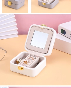 Macro detail of white square jewelry box interior with mirror and ring slots