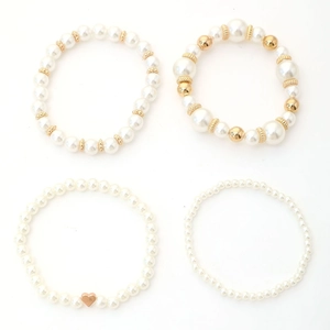 Chic four-piece beaded bracelet set featuring faux pearls and golden heart charm accents
