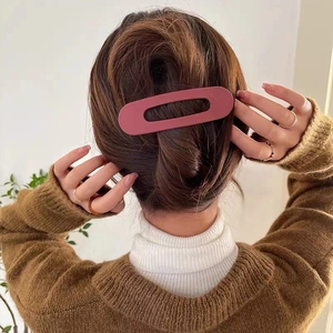 Large matte dusty rose oval hollow hair clip shown worn on a female model