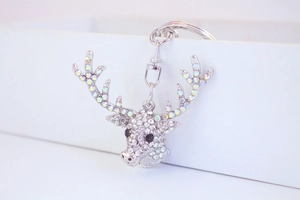Macro shot of silver deer head keychain with sparkling rhinestones in a white gift box