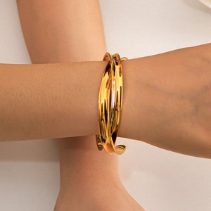 Polished 18K gold plated stainless steel C-shaped open bangle for women on a model