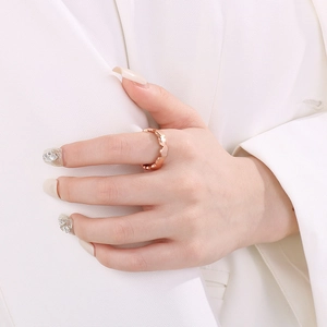 Elegant rose gold hollow heart-shaped stainless steel ring worn on index finger