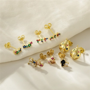 Detail view of 925 silver gold plated insect and bow earrings with colorful zircons