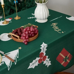 Detailed fabric texture of a dark green Christmas tablecloth with Santa and reindeer prints