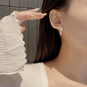 Detail view of 925 sterling silver hoop earrings with sparkling zircons on female model