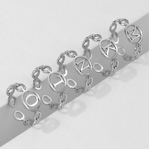 Macro detail of silver adjustable open rings featuring hollow alphabet chain designs