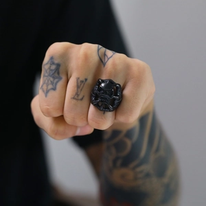 Detail of a matte black skull ring featuring intricate skull structure and side engravings