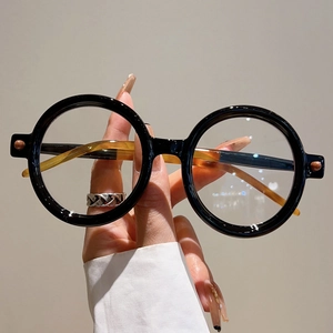 Gros plan détaillé de lunettes de soleil rondes rétro avec monture noire et branches écaillées