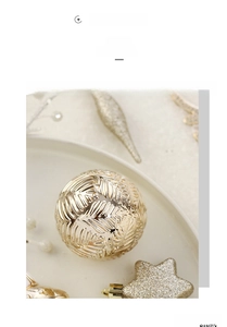 Vue détaillée d'une boule de Noël dorée avec motif de feuilles sur assiette blanche