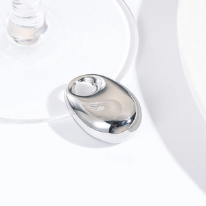 Macro view of a smooth silver oval drop pendant with a small hole for DIY jewelry making