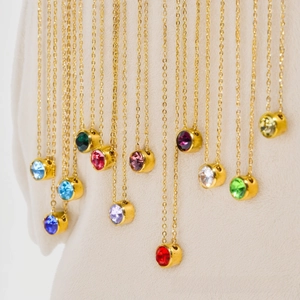Detail of colorful round birthstone pendants on delicate gold stainless steel chains