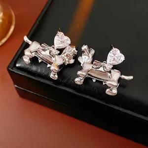 Silver dachshund earrings with heart cubic zirconia and bow detail on jewelry box