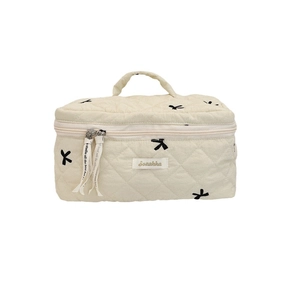 Beige quilted makeup bag with black bow embroidery and convenient top handle