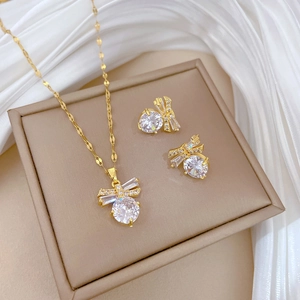 Elegant gold butterfly jewelry set with zircon necklace and earrings on silk background