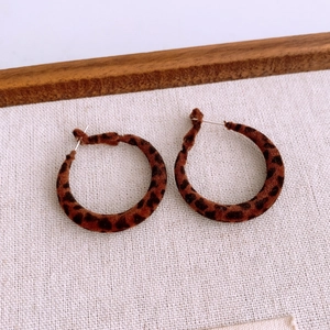 Macro shot of brown leopard print fabric hoop earrings with soft flocked texture finish