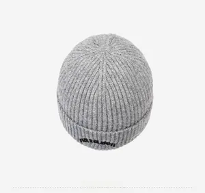 Top view of gray knit beanie showing detailed vertical ribbed texture and black embroidery