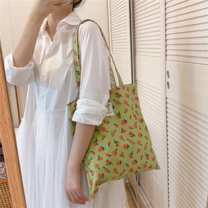 Detailaufnahme der grünen Stofftasche mit roten Tulpenmustern und seitlichem Etikett