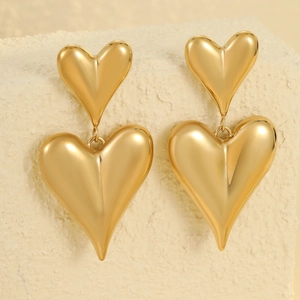 Orecchini minimalisti a doppio cuore in acciaio inossidabile placcato oro 18K su sfondo beige