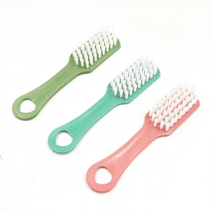 Three colorful plastic shoe brushes with soft white bristles for effective laundry cleaning