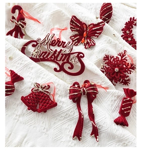 Red flocked velvet Christmas ornaments set with gold glitter on white fabric detail
