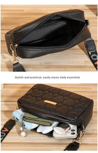 Detail of black heart-quilted crossbody bag interior showing phone and wallet storage