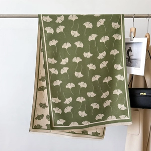 Detail of green ginkgo leaf jacquard pashmina shawl with tassels and double-sided color