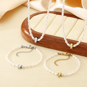 Detail of 4mm white rice pearl necklace and bracelet set with girl charm pendants