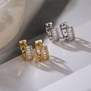 Macro detail of gold and silver plated hoop earrings with baguette cut zircons