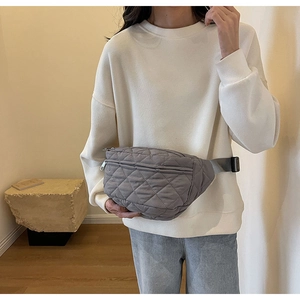 Detail of gray quilted nylon crossbody chest bag shown on model for a trendy autumn look