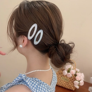Model wearing white oval acetate hair clips with pearl jewelry and blue checkered top