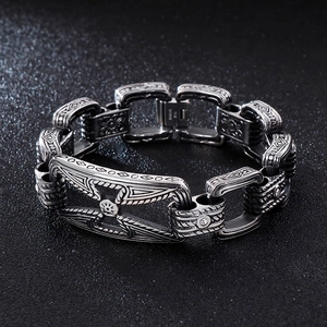 Macro shot of retro stainless steel bracelet links with etched geometric cross pattern