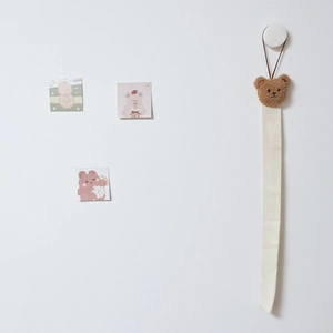 Detail of beige hanging hair accessory organizer with a cute brown plush bear head