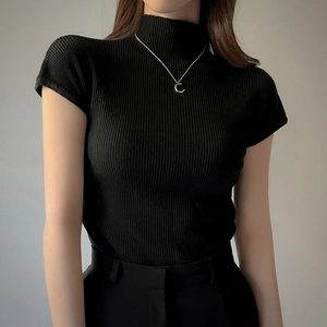 Dettaglio maglia nera a costine a maniche corte con elegante design a lupetto alto