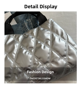 Detail of silver metallic quilted tote bag with diamond stitching and black strap