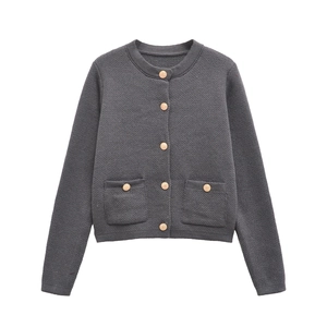 Close-up of dark grey knitted cardigan featuring ornate golden embossed buttons and pockets