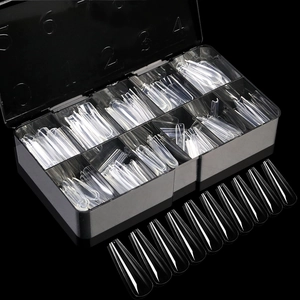 Macro detail of clear coffin nail tips with size numbers in a black storage case